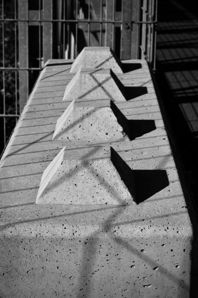 Black and white abstract photo capturing shadows on a geometric concrete structure with unique patterns.